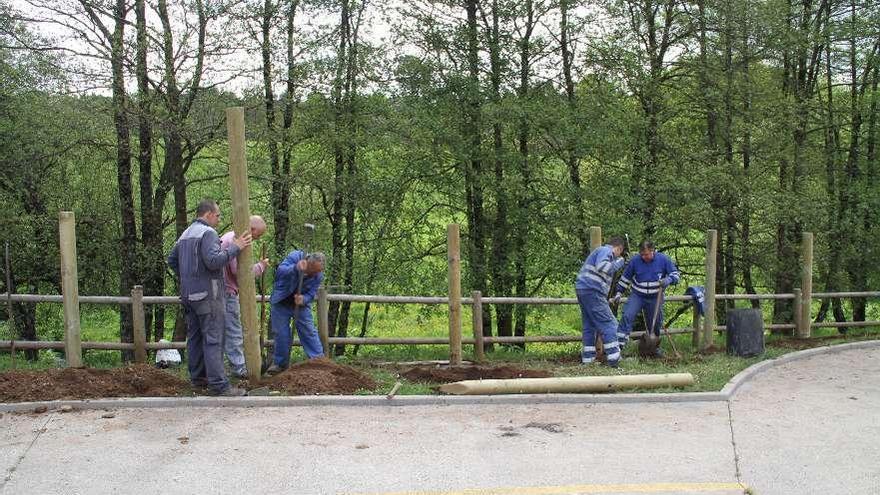 Operarios municipales colocan postes para el vallado de protección en una parte del trazado.