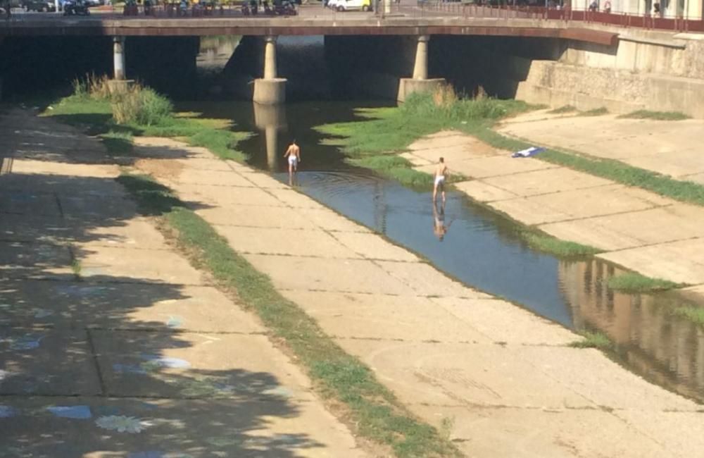 Dos joves s''han refrescat aquest dimecres a les aigües de l''Onyar al centre de Girona