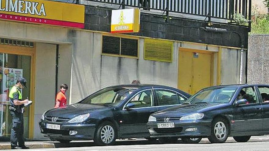 Un policía local de Carreño multando a un vehículo en la calle Reina María Cristina, en una foto de archivo.