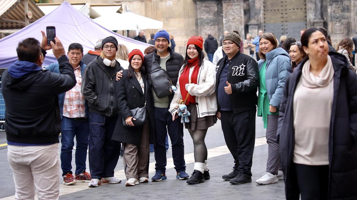 Turistas extranjeros fotografiándose con la Catedral de Murcia en la Plaza Belluga.
