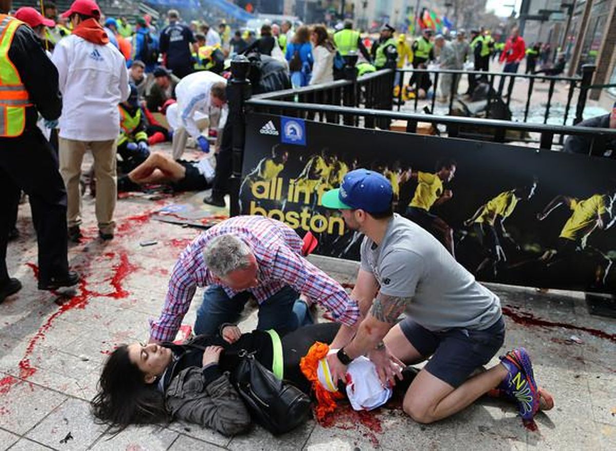 Una dona ferida és atesa a terra a prop de la meta de la Marató.
