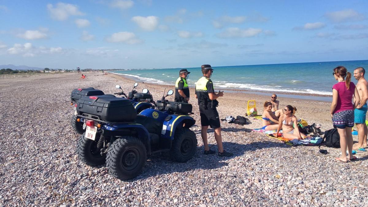 Unos agentes, informando en la playa.