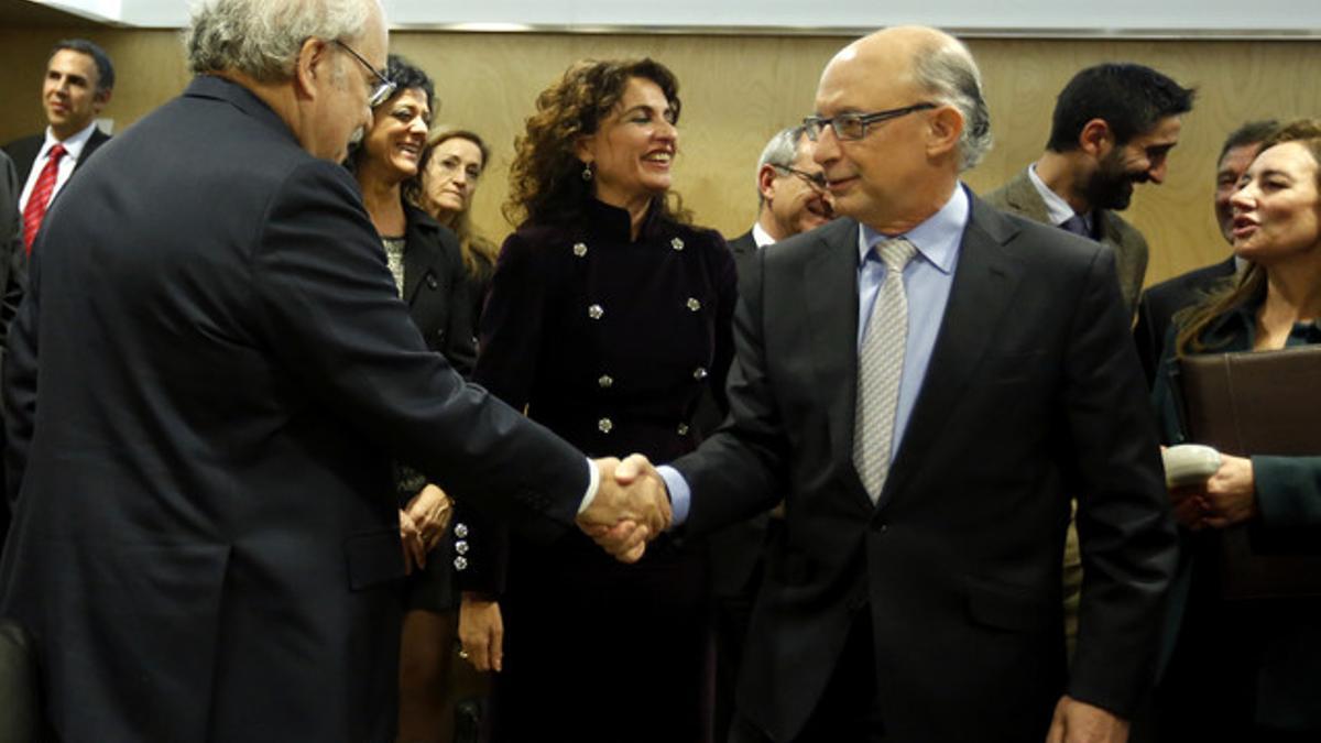 El 'conseller' de Economía catalán Andreu Mas-Colell saluda al ministro de Economía Cristóbal Montoro, este martes, en el Consejo de Política Fiscal y Financiera.