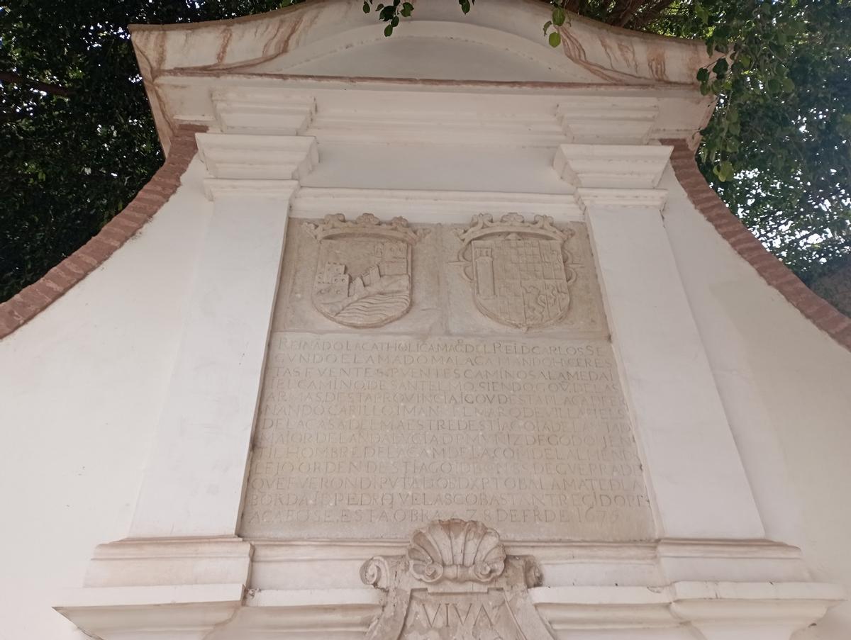 Escudos de Málaga y de don Fernando Carrillo sobre la lápida conmemorativa de la Fuente de Reding, antes conocida como la Fuente del Marqués.