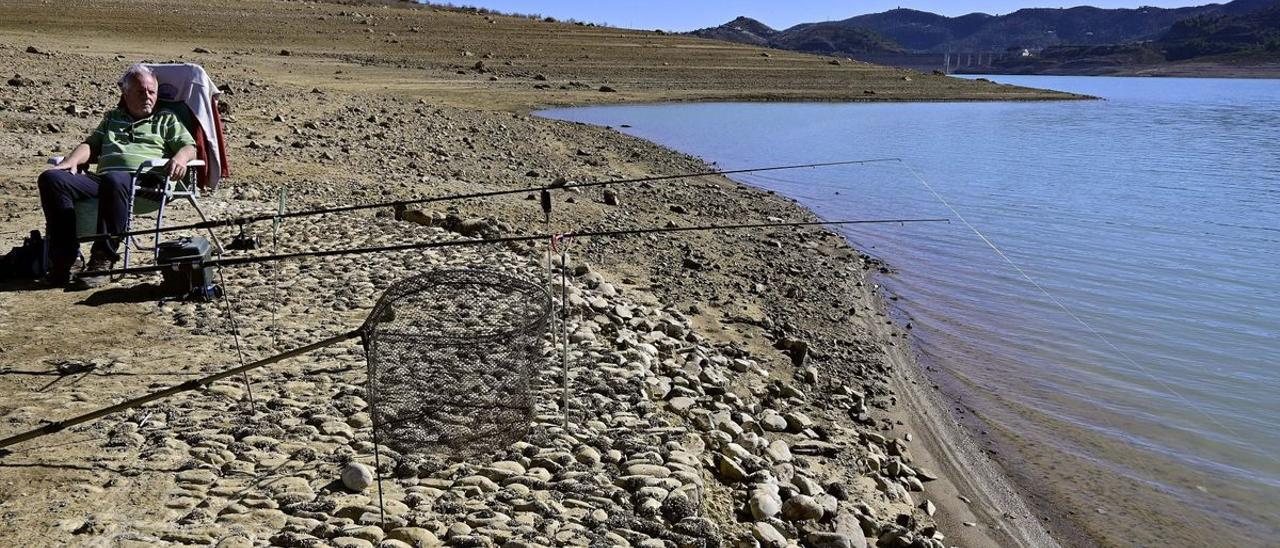 Una persona pesca en el Embalse de la Viñuela, en provincia de Málaga, que oficialmente se encuentra en situación de sequía grave al haber superado el umbral de 41,5 hectómetros cúbicos.