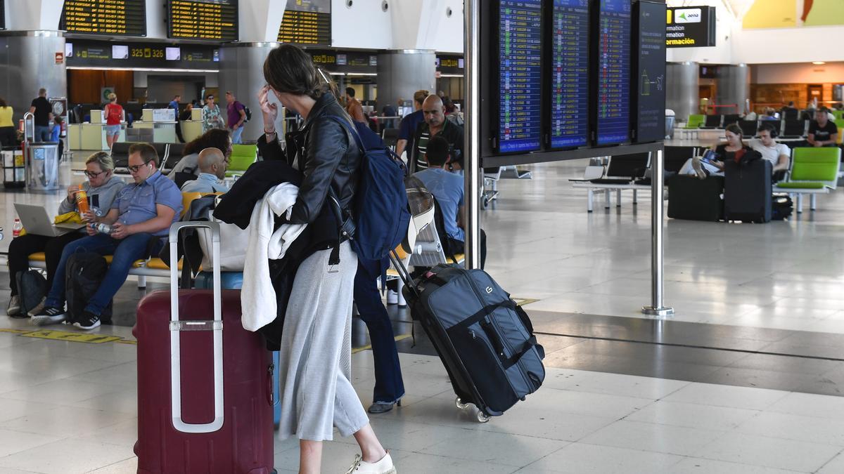 Una pasajera en el aeropuerto junto a sus maletas.