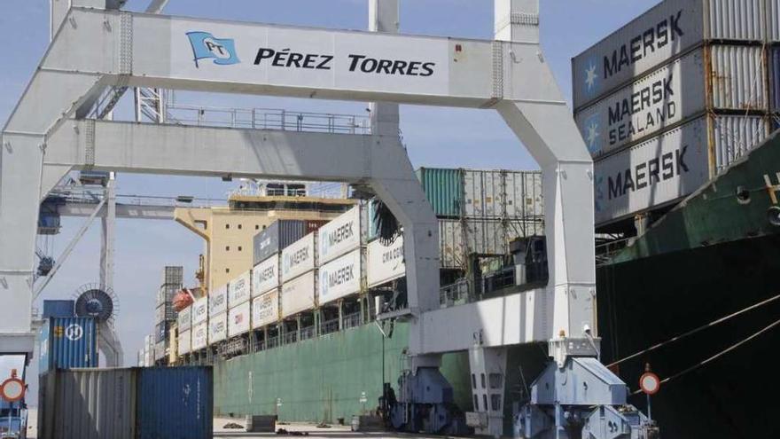 Una de las grúas de Pérez Torres ante un barco de Maersk cargado con contenedores.  // S. Álvarez