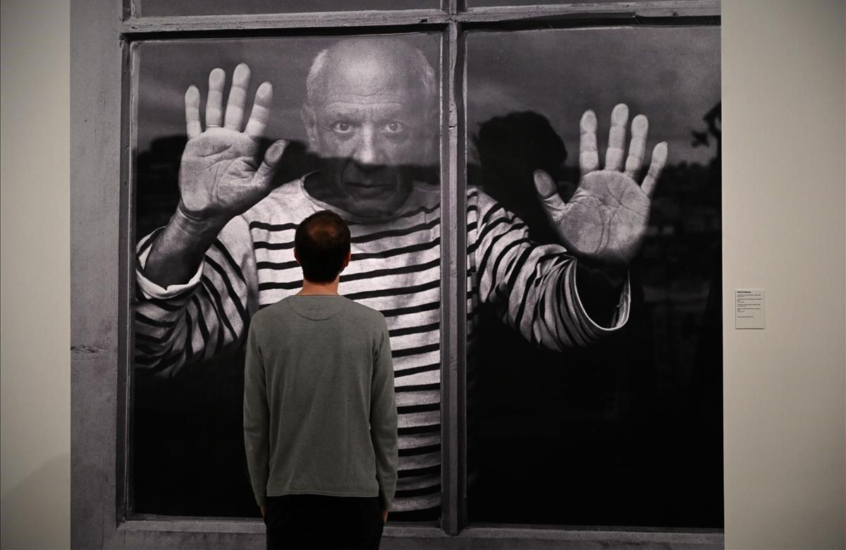 Un hombre mira una imagen del fotógrafo francés Robert Doisneau titulada ’The Fate Line Pablo Picasso’, realizada en Vallauris 1952 durante la presentación de la exposición fotográfica de Picasso en el Museo Picasso de Barcelona.