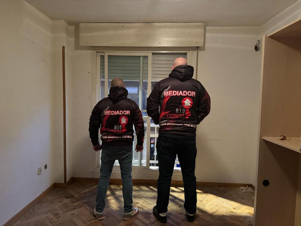 Dos empleados de una firma de desalojo exprés, tras recuperar una vivienda en Vigo.