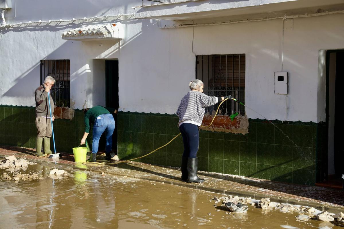 Los vecinos de la barriada de Doña Ana en la Estación de Cártama, junto al operarios Infoca, limpian los estragos de la nueva inundación provocada por la crecida del Guadalhorce durante la borrasca Francis