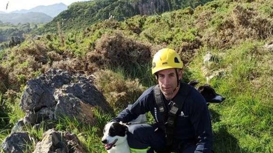 El bombero, con el perro rescatado y la otra mascota detrás.