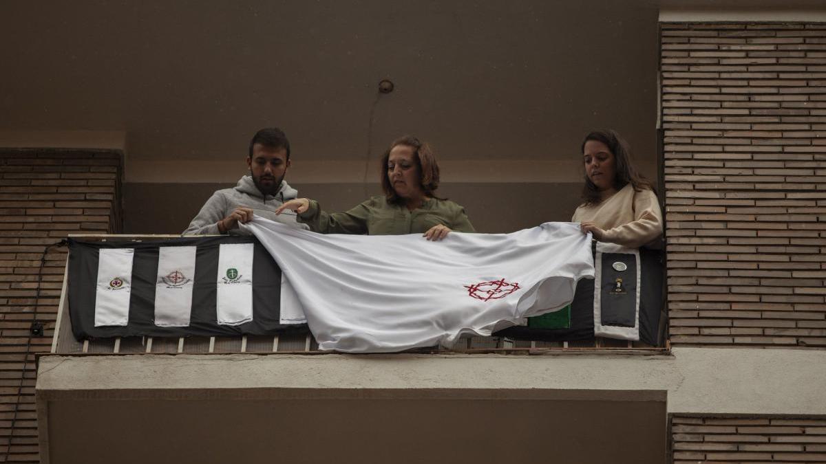 Hermanos de La Tercera Caída cuelgan la túnica en el balcón, la tarde de este Lunes Santo.