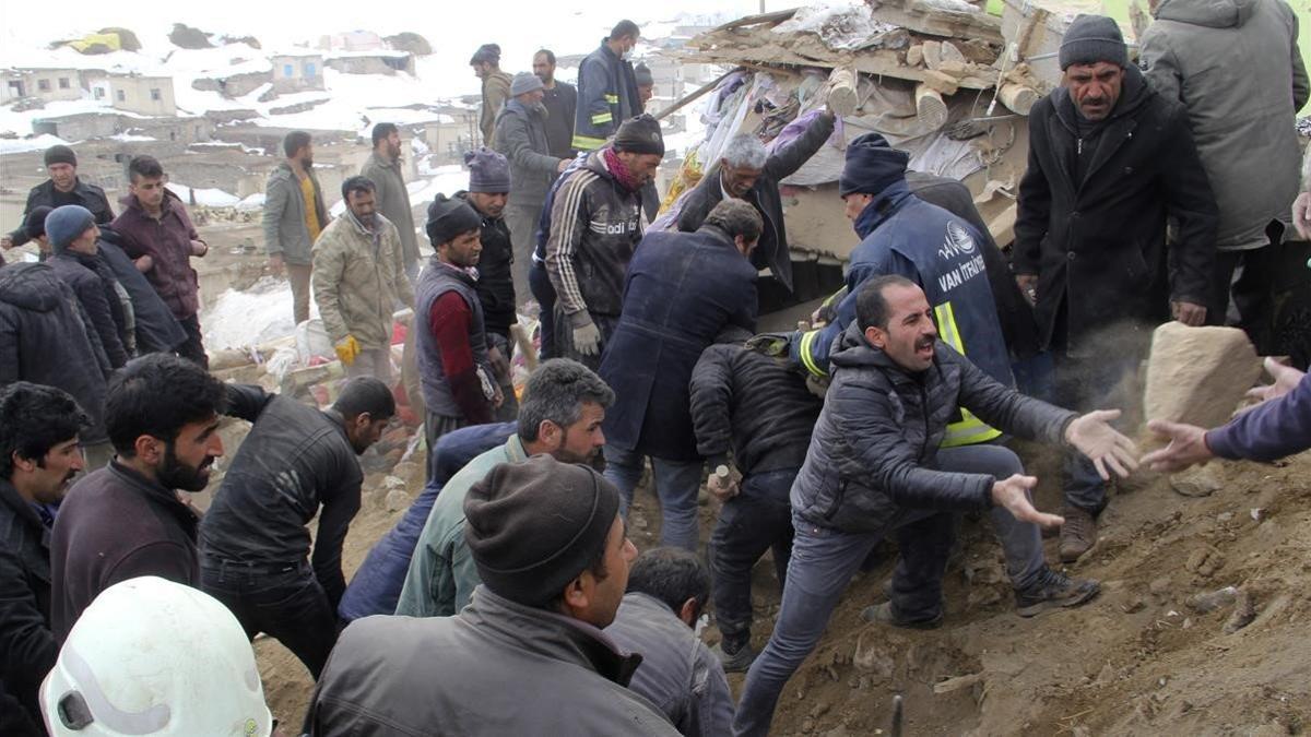 Un grupo de hombres se afanan en retirar escombros en busca de supervivientes, en la población de Baskale este domingo.
