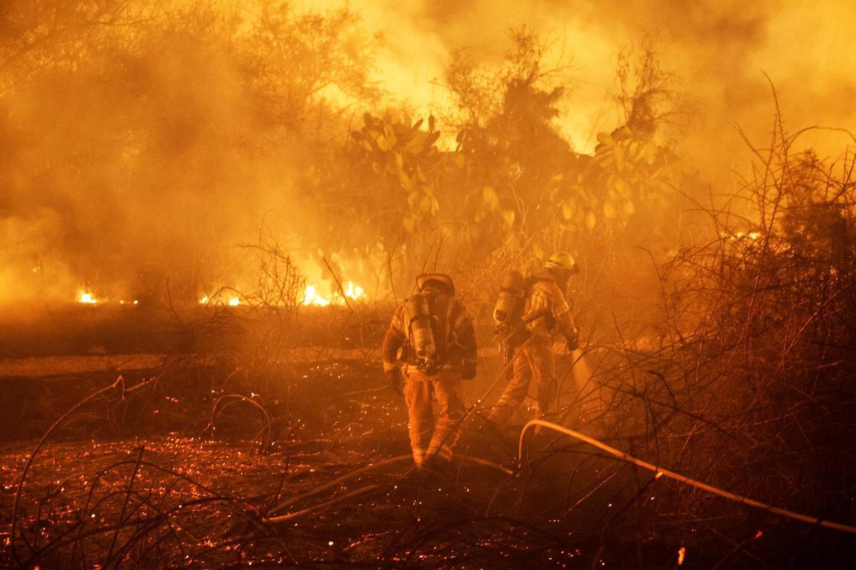 Los bomberos trabajan para apagar un incendio en un campo abierto, tras una infiltración masiva de hombres armados de Hamás desde la Franja de Gaza, cerca de un hospital en Ashkelon, en el sur de Israel.