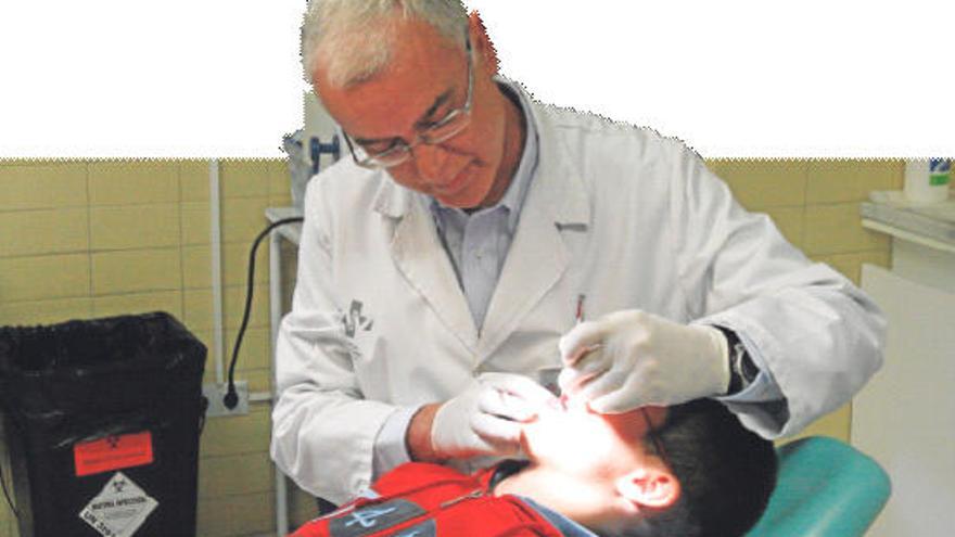 Un odontólogo revisando el estado de la dentadura de un niño.