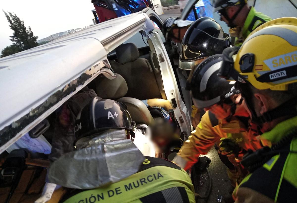 Bomberos del Consorcio de Extinción de Incendios y Salvamento de la Región de Murcia (CEIS) trabajando en el rescate de los ocupantes de la furgoneta-