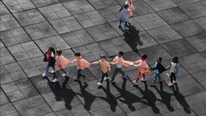 Alumnos de un colegio juegan en el patio mientras hacen una fila.