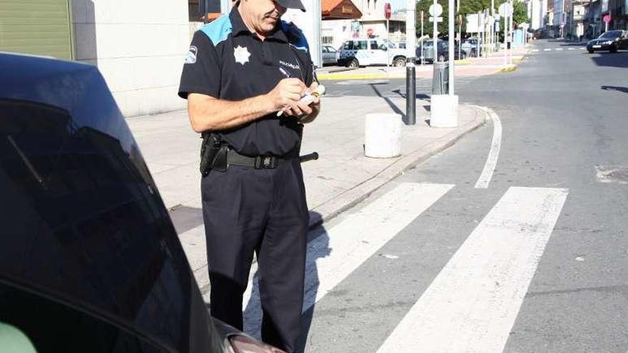 Un agente de Bueu poniendo una multa. // C.G.