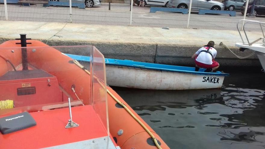 Un voluntario amarra una de las pateras en la que viajaban siete ocupantes.