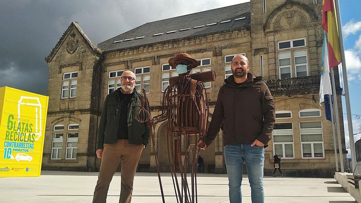 Manuel Lago Román y su hijo Xoán posan junto al peregrino metálico frente al consistorio.  | // L.D.