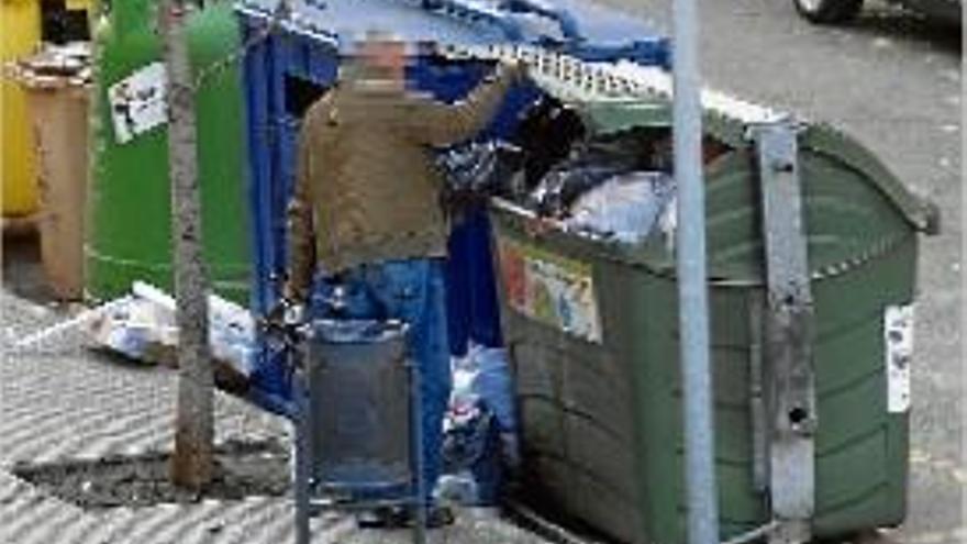 Una persona buscant entre les escombraries, a Manresa