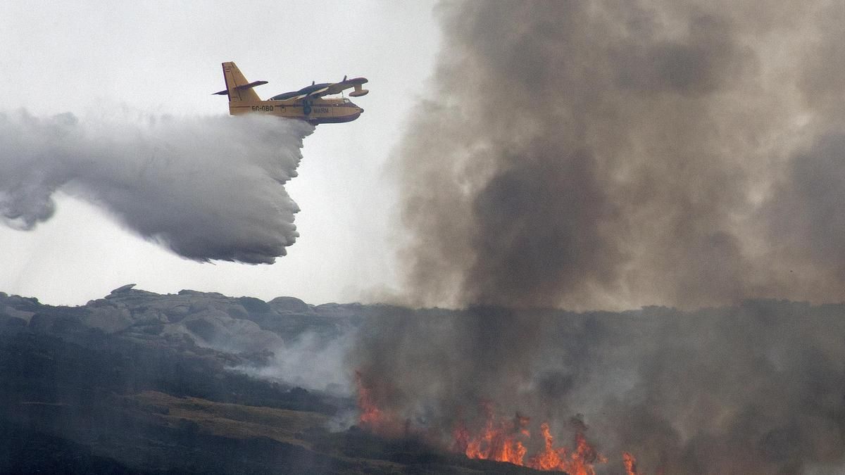 Un hidroavión, realiza una descarga en un incendio forestal.