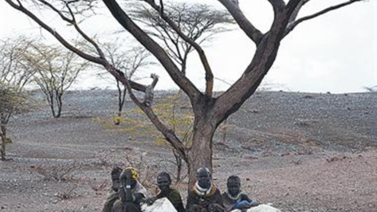 Cinco pastores de Turkana (Kenia) esperan una ración de comida.