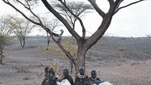 Cinc pastors de Turkana (Kenya) esperen una ració de menjar.