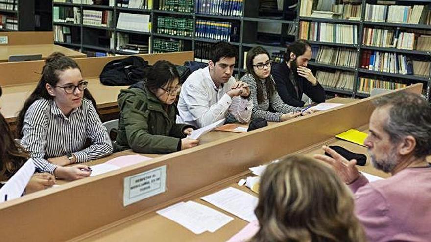 Profesores y alumnos del taller de escritura creativa se reúnen en la biblioteca del IES Universidad Laboral durante las horas de recreo.