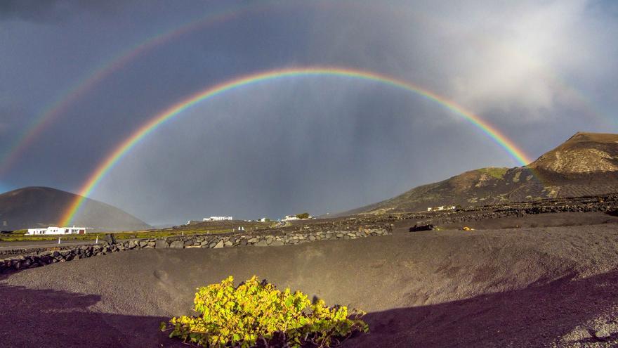 Tiempo con cielos poco nubosos este sábado en Canarias. Arcoíris en La Geria tras las lluvias de esta semana en Lanzarote.