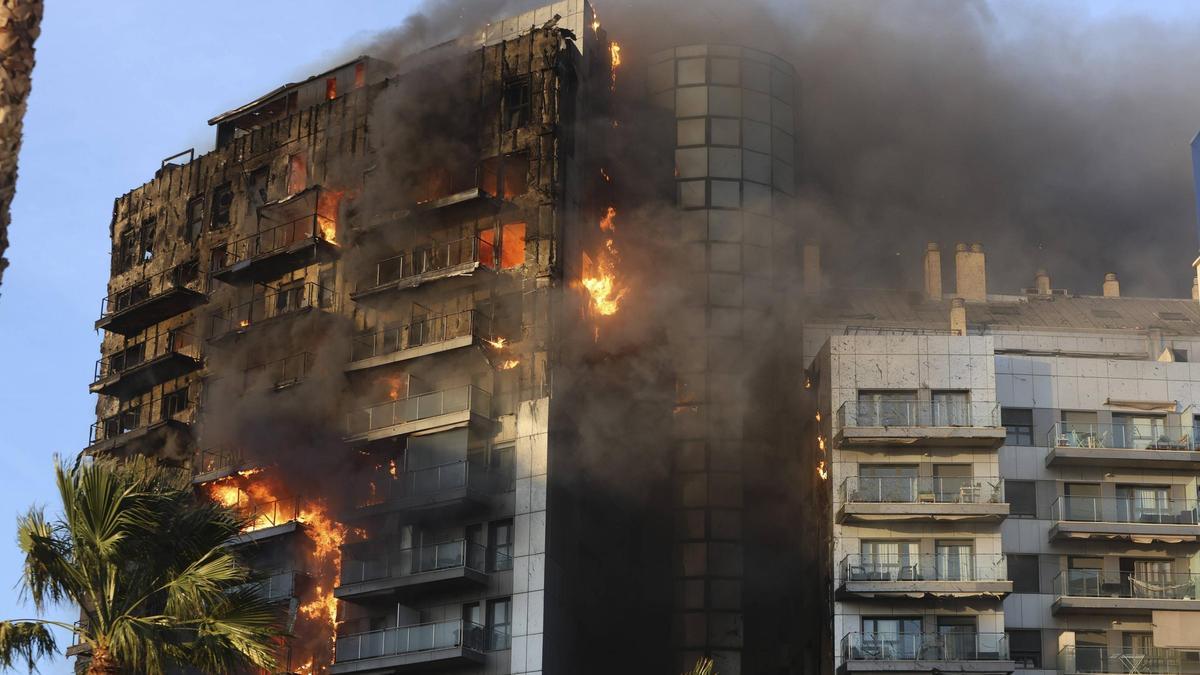 El fuego devora uno de los dos edificios de Maestro Rodrigo, en València, mientras el viento dobla las hojas de las palmeras.