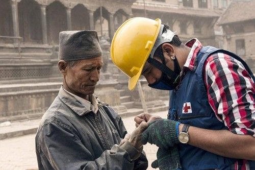 Un socorrista de la Cruz Roja Internacional ayuda a una persona herida en Katmandú