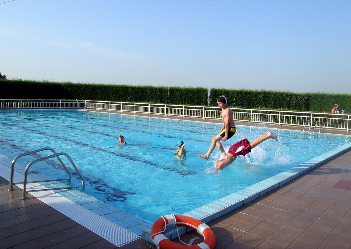 Unos chicos saltan a una piscina.