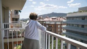 Una mujer mayor en el balcón de su casa en Barcelona.
