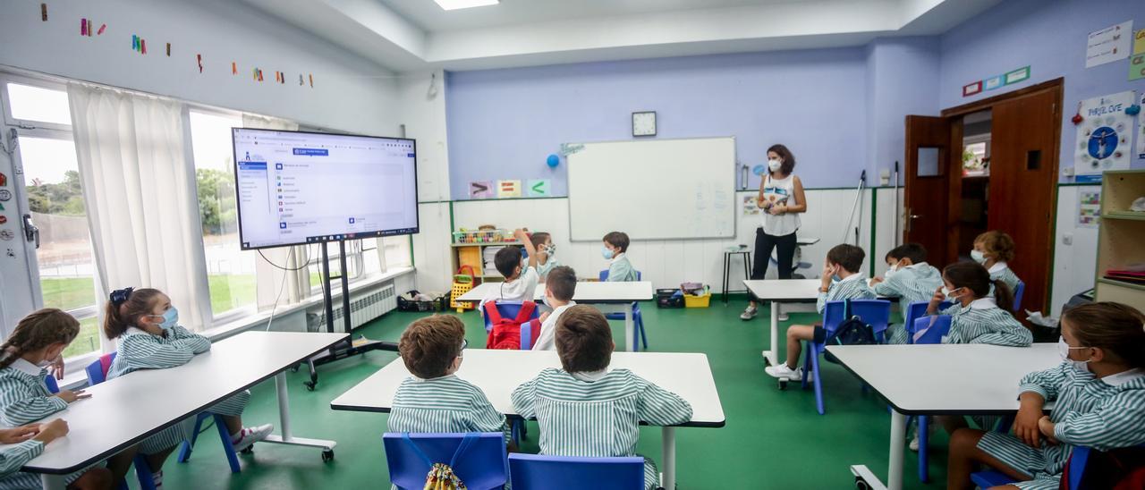 Varios niños escuchan las explicaciones de su profesora en una clase del colegio Virgen de Europa durante el primer día de clase del curso 2021-22, a 6 de septiembre de 2021, en Boadilla del Monte, Madrid (España).