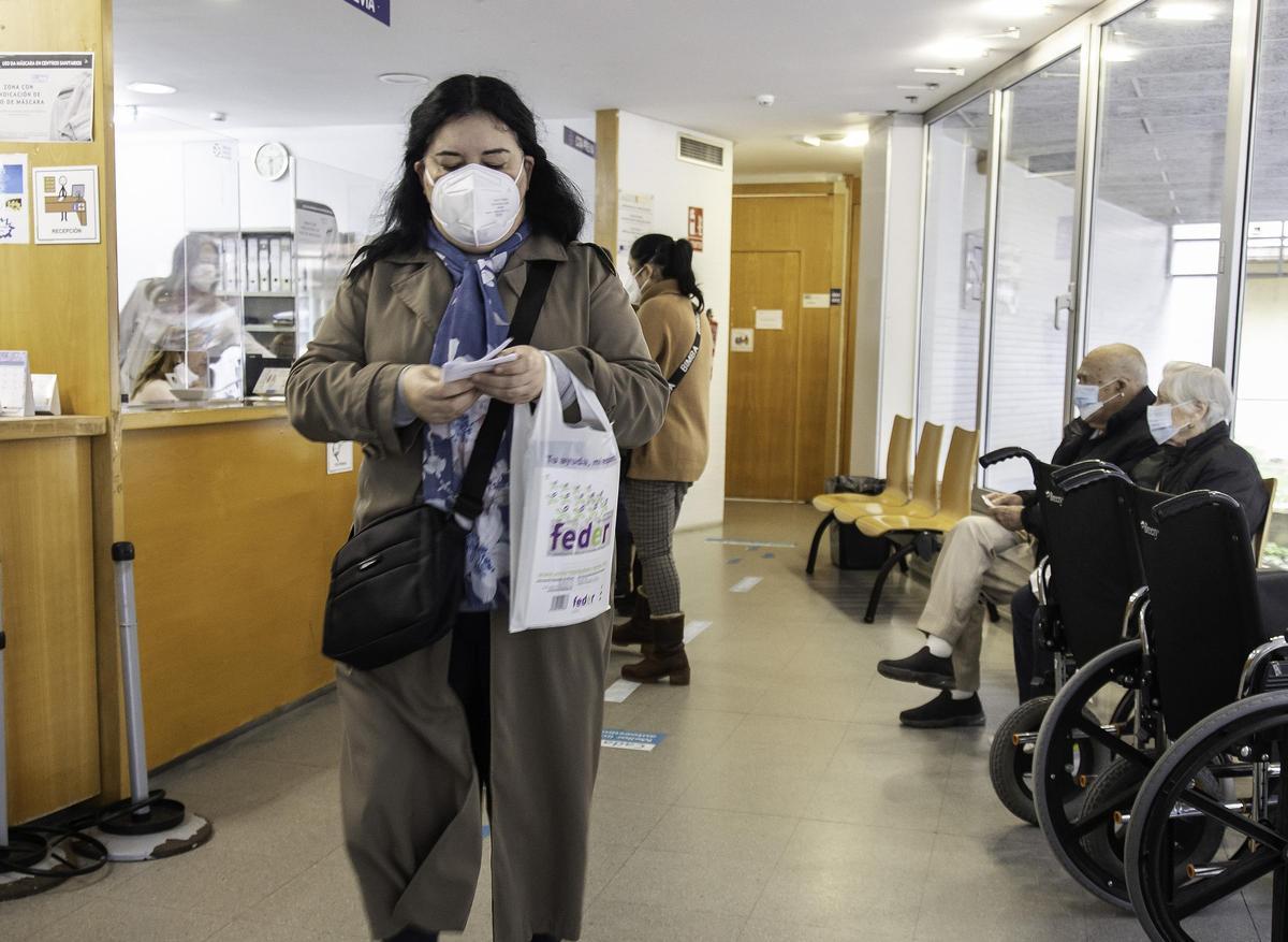 Una mujer sale de un centro de salud de Vigo, donde todos los pacientes llevan mascarilla.