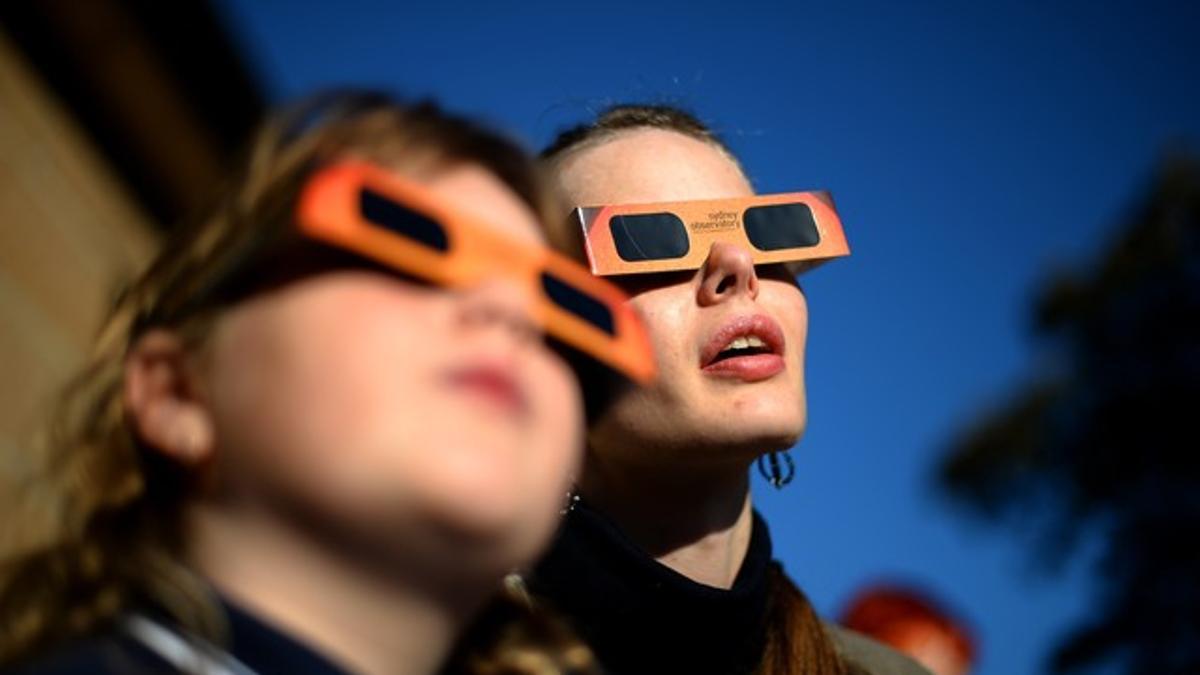 Una mujer y una niña contemplan un eclipse parcial de sol, en Sídney, en mayo del 2013.