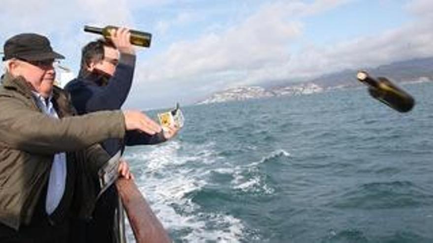Un dels restauradors llançant una ampolla al mar