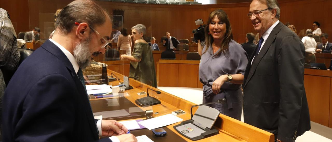 El presidente de Aragón, Javier Lambán, sonríe ante la consejera de Sanidad, Sira Repollés, y el consejero de Hacienda, Carlos Pérez Anadón, a primera hora de este pleno.