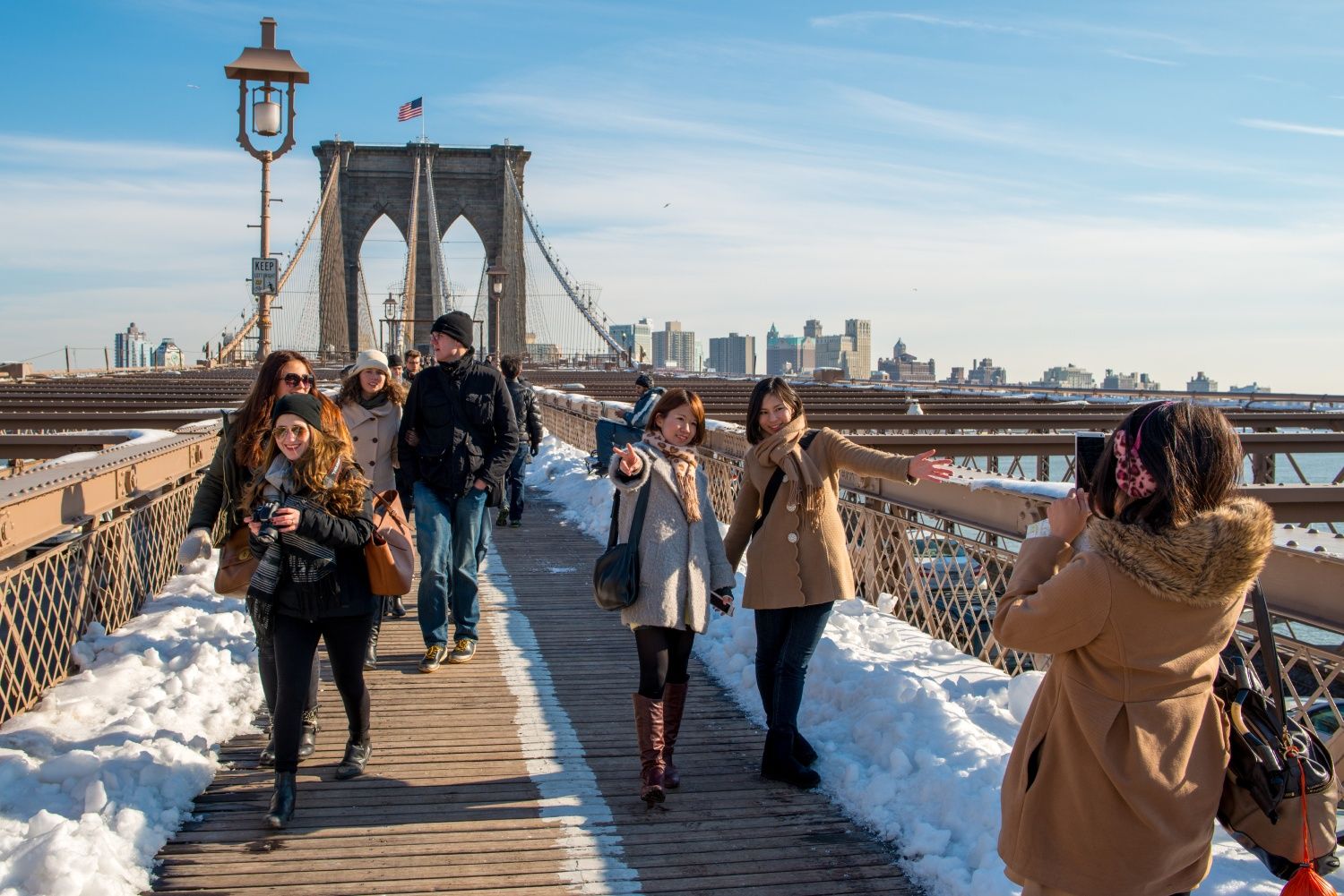 Viajeros de todo el mundo se fotografian en el puente de Brooklyn.