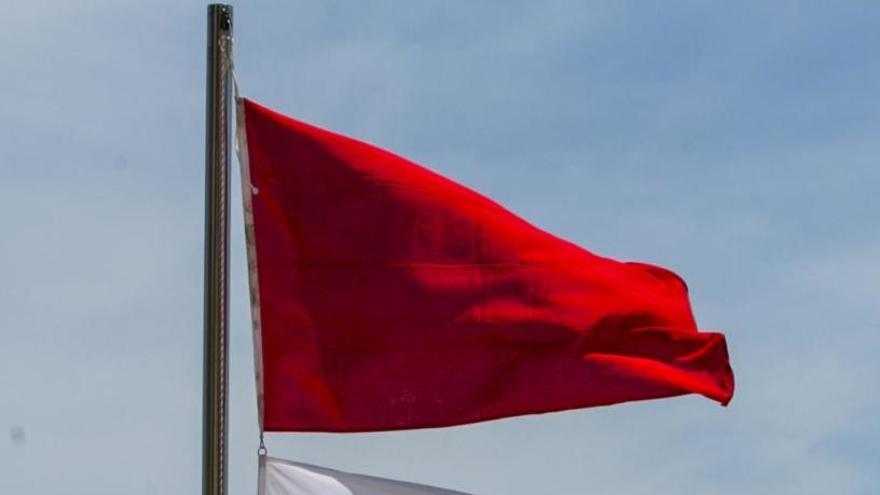 Una bandera roja ondeando en Los Arenales