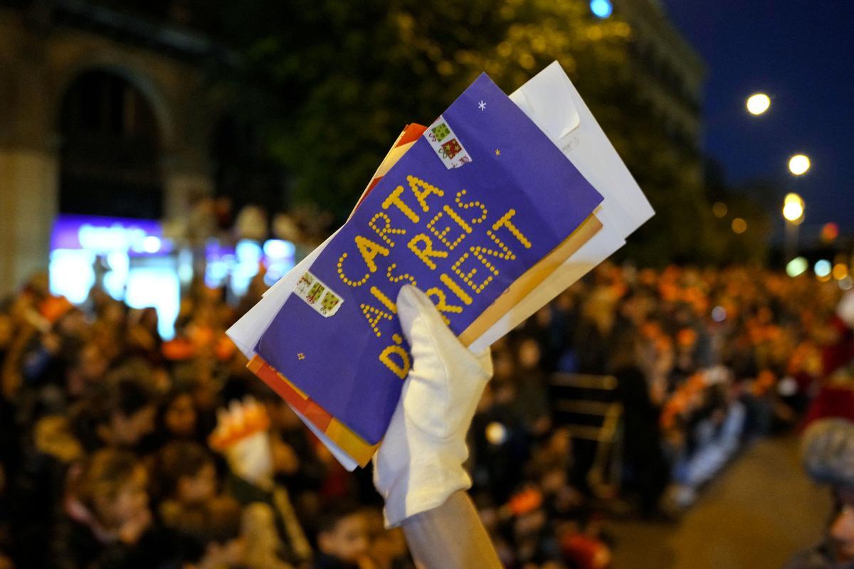 Los pajes de sus majestades de Oriente recogen las cartas de niños y niñas durante la cabalgata de Reyes Magos en la ciudad de Barcelona; una cabalgata que recupera la normalidad tras la pandemia, que estrena nuevas carrozas y que congrega este jueves a decenas de miles de personas, convirtiéndola en la más multitudinaria del Mediterráneo. 