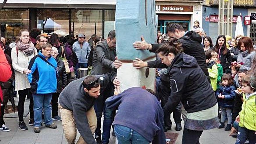 El Xukli gegantí és conduït a través de la plaça Major cap al cadafal per un grup de persones.