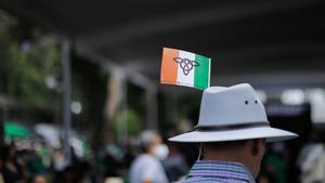 Un hombre con una bandera irlandesa en su sombrero