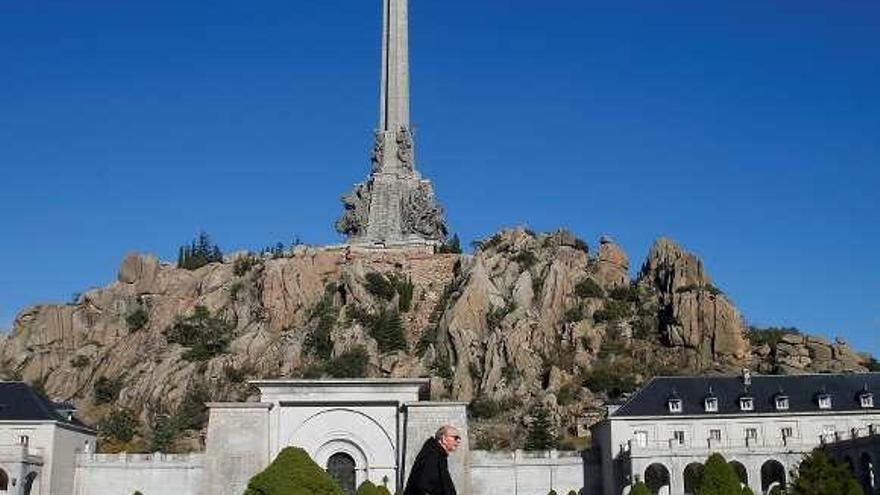 Un monje camina delante de la cruz del Valle de los Caídos. // Reuters