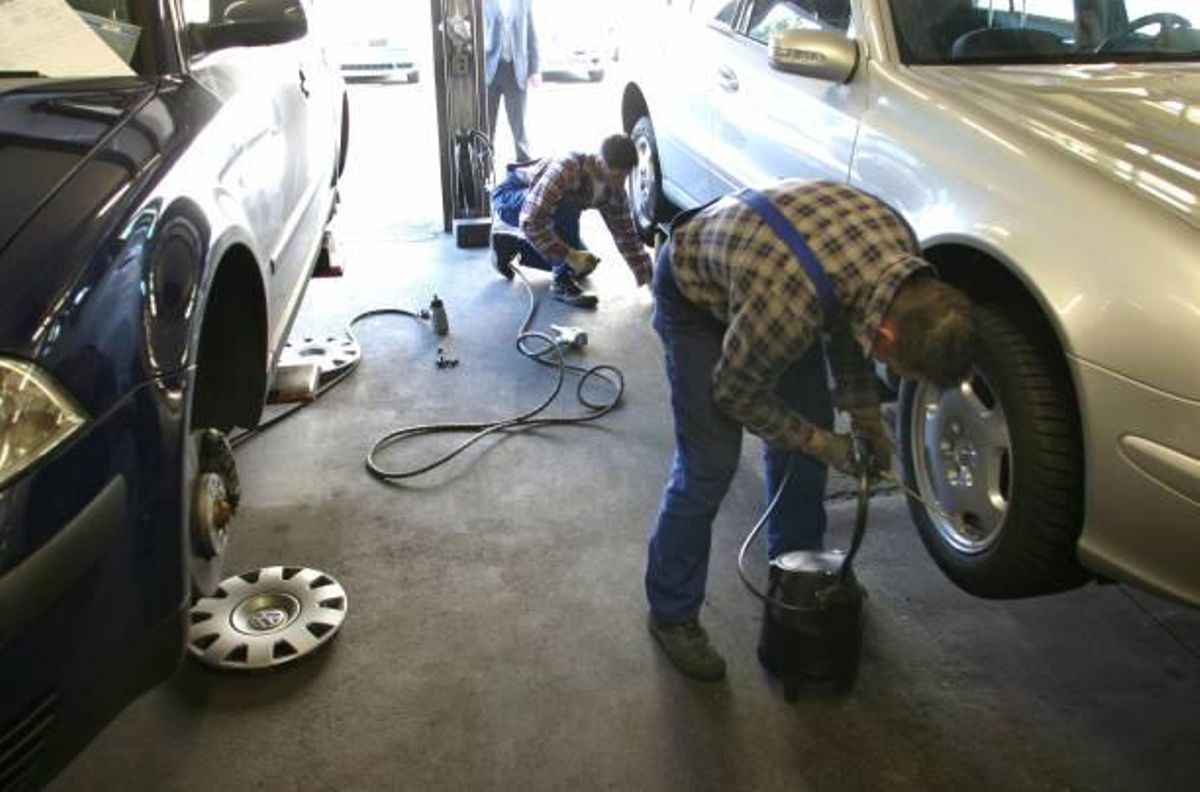 Mecánicos cambiando los neumáticos de un coche