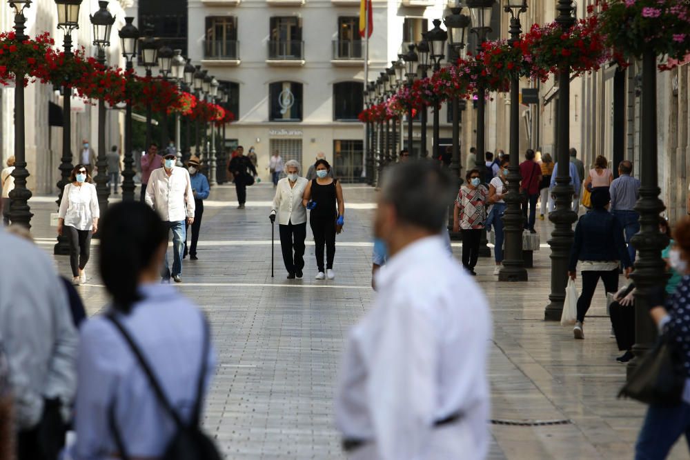 Mascarillas y guantes ya se han convertido en un complemento más de los malagueños, que siguen aprovechando las franjas horarias permitidas para dar sus paseos mientras los pequeños establecimientos se preparan para una reapertura cuando el progreso en la desescalada lo permita