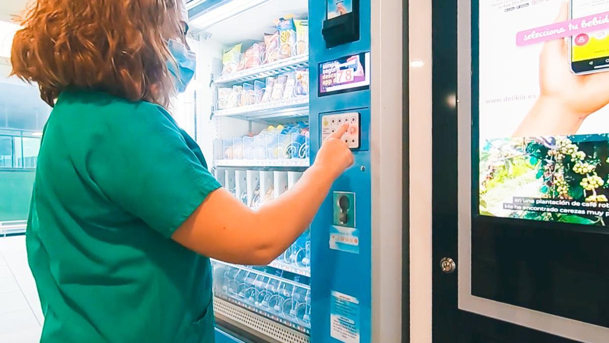 Una sanitaria utiliza el sistema &quot;contactless&quot; en una máquina de vending del Hospital Álvaro Cunqueiro