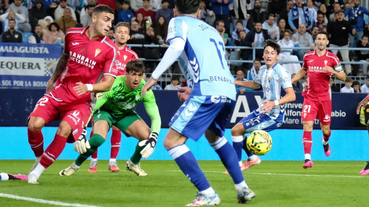 Iker Álvarez, al fondo de la imagen, durante un lance del Málaga-Córdoba CF.