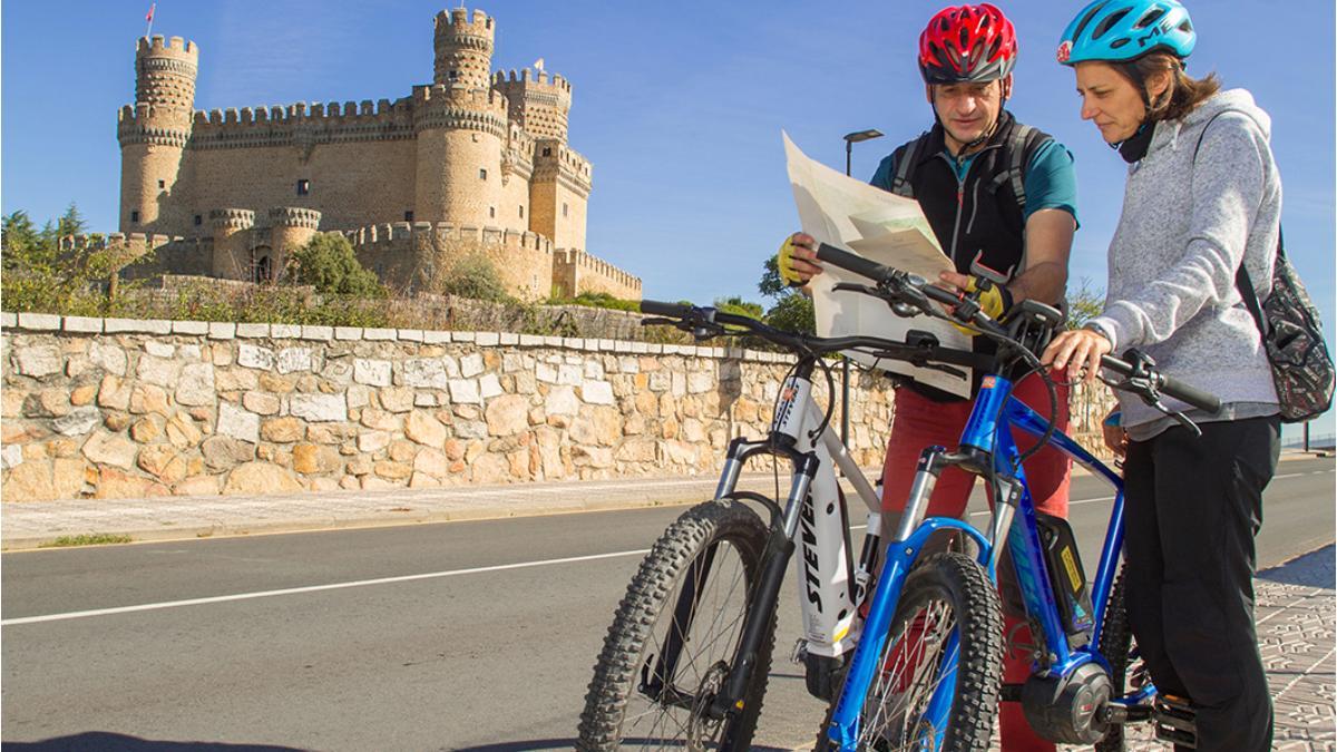 Una pareja de cicloturistas en Manzanares El Real, punto de llegada y salida de una de las etapas del Gran Tour.